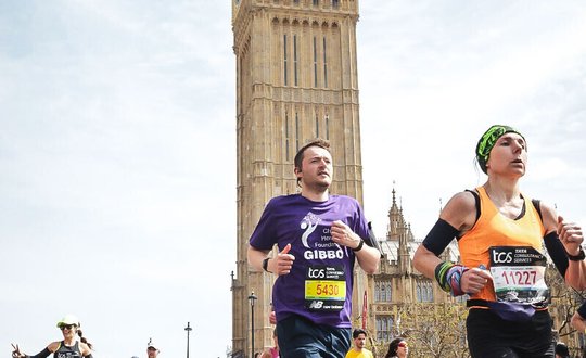 Man Running with big ben behind him.