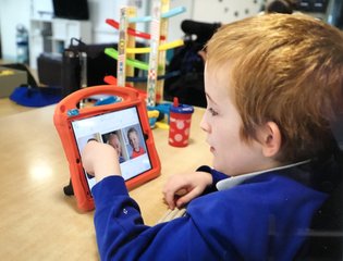 Young boy learning on an ipad.
