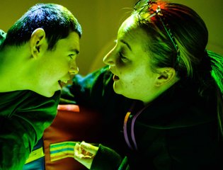 Young person and support worker looking at each other.