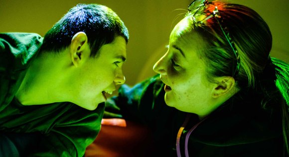 Young person and support worker looking at each other.