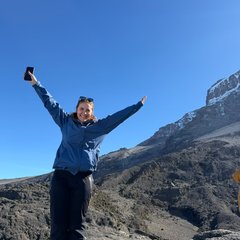 Women on top of a mountain with her arms in the air.