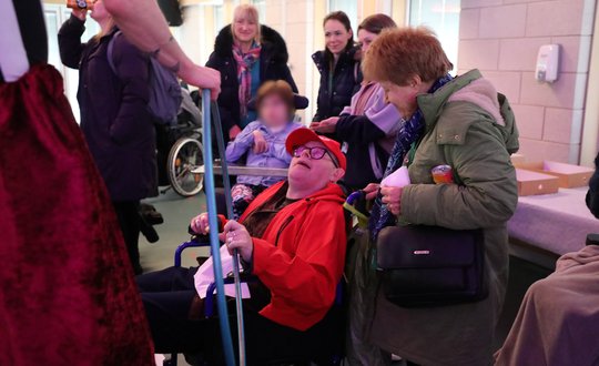 Man holding hula-hoop with circus performer.