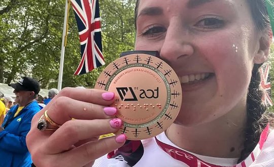 Girl smiling up close to her medal.