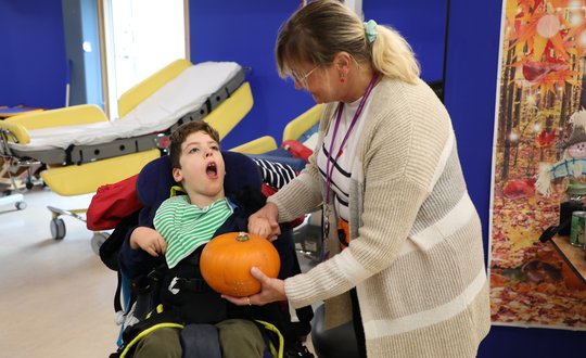 Boy touching a pumpkin.
