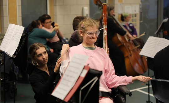 Girl watching people play instruments.