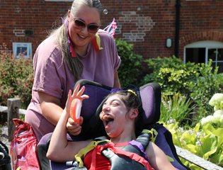 Girl smiling at her support worker dressed colourful.