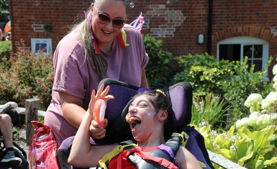 Girl smiling at her support worker dressed colourful.
