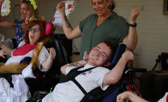 Boy smiling in makaton choir.