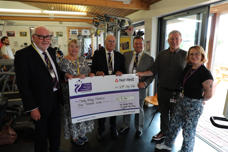 Group of club members holding a big cheque.