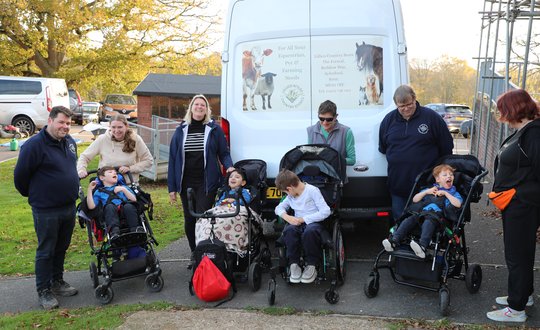 Group of people standing in front of a Saracen white van