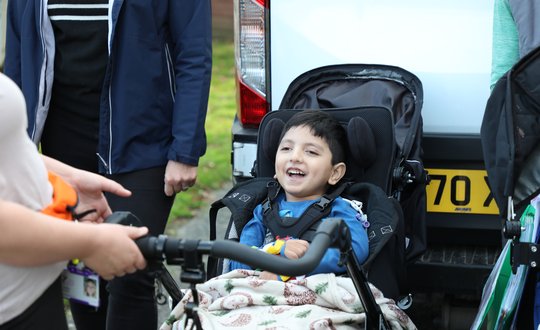 Smiling little boy in front of a white van