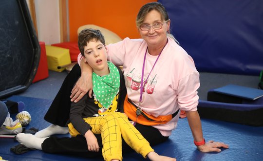 Young boy sitting with career.