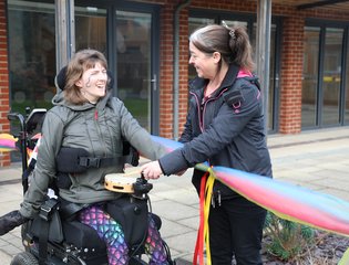 young person and TA holding colourful yarn