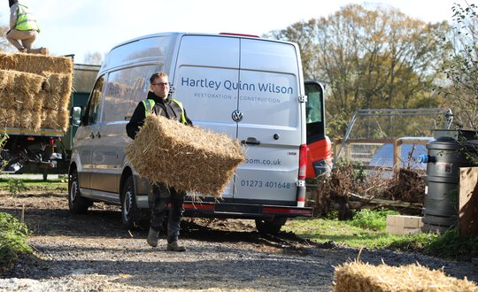 Man carrying a bale of hay