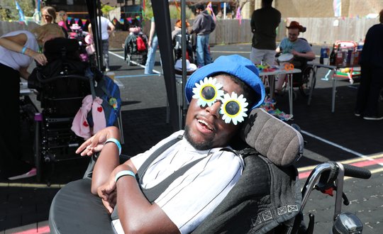 Boy with flower sunglasses smiling.