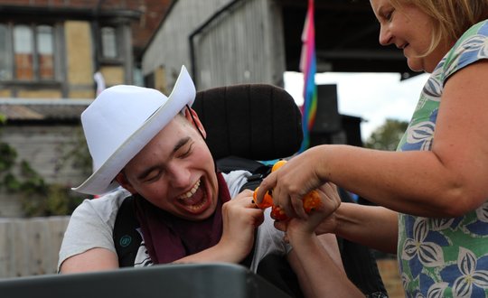 Boy smiling with a cowboy hat on.