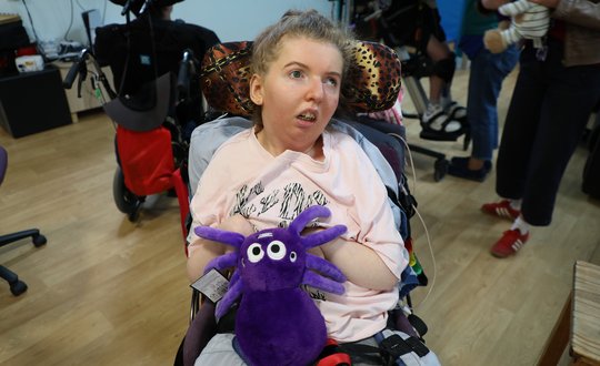 Girl with a purple spider teddy bear.