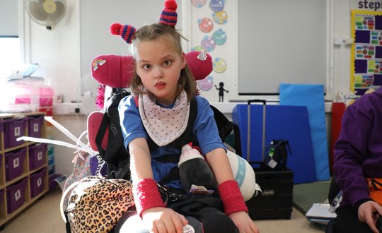 Young girl looking at the camera with two woolly hats on.