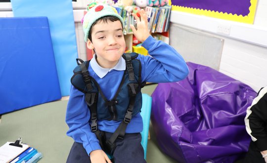 Boy smiling at the camera with a woolly hat.