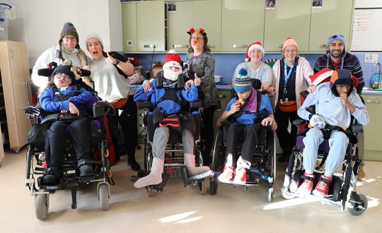 A class with woolly hats posing for a photo.