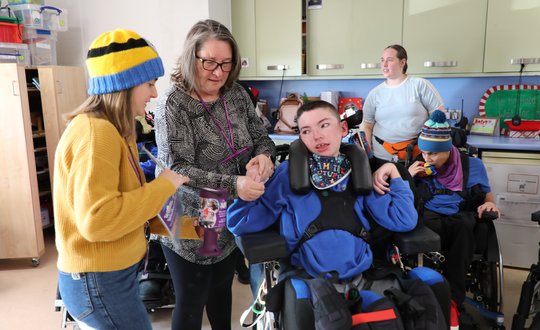Young boy donating money into a pot.