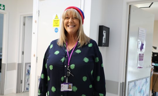 Women smiling with a Santa hat on.