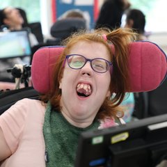 Girl smiling with purple glasses.