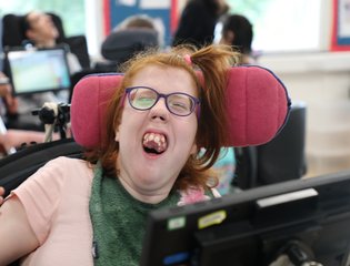 Girl smiling with purple glasses.