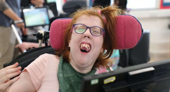 Girl smiling with purple glasses.