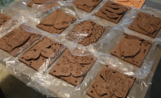 Clay tiles laid out on a table.
