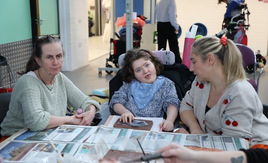Girl smiling at the camera while sculpting clay.