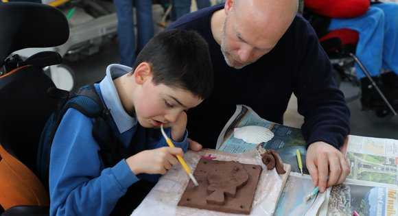 Boy sculpting clay.