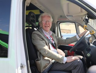 Volunteer driver smiling in van