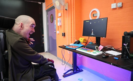 Man in wheelchair playing accessible space invaders.