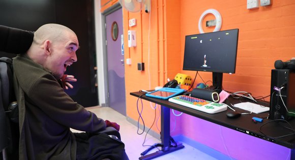 Man in wheelchair playing accessible space invaders.