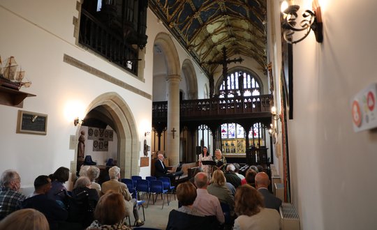 Chapel view with two women singing at the end.
