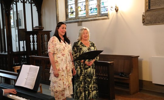 Two women singing in the chapel.