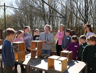 Group of people crowding round a table.