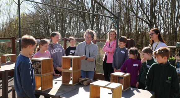 Group of people crowding round a table.