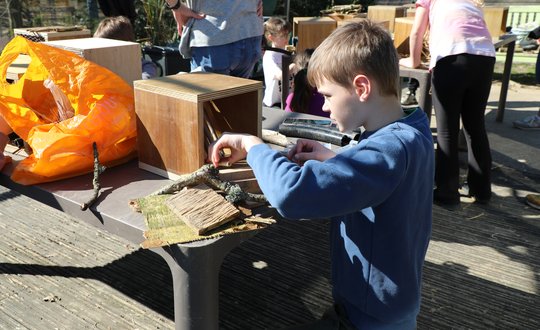 Boy building with sticks.