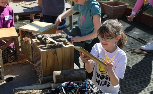 Girl smiling with staw in her hands.