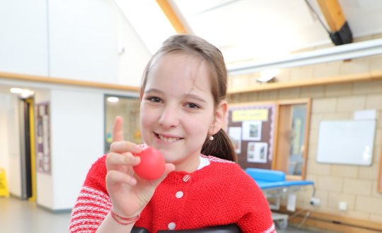 Girl smiling with a red nose.