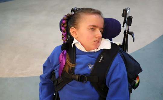 Young girl with purple ribbon in her hair.