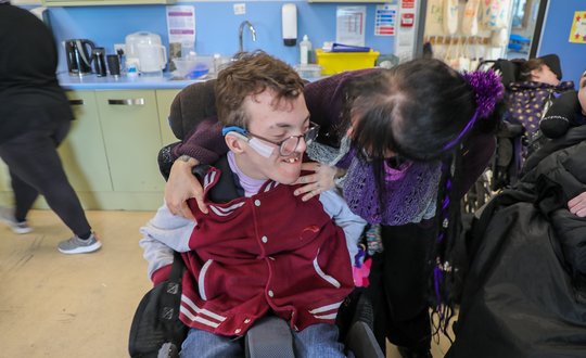 Boy smiling at support worker.