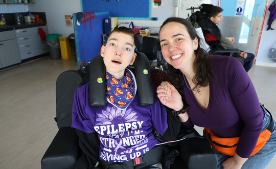 Boy and support worker with purple tops.