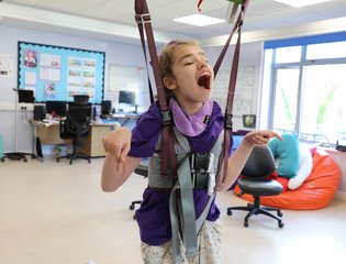 Girl in standing sling smiling and laughing.