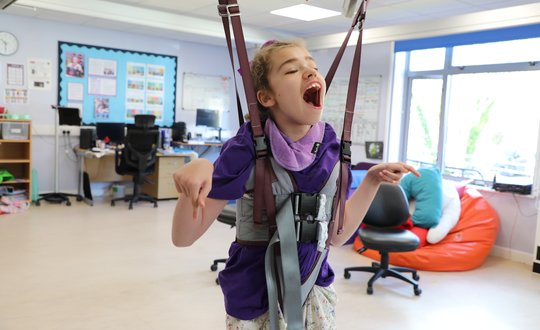 Girl in standing sling smiling and laughing.