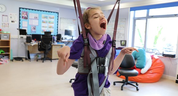 Girl in standing sling smiling and laughing.