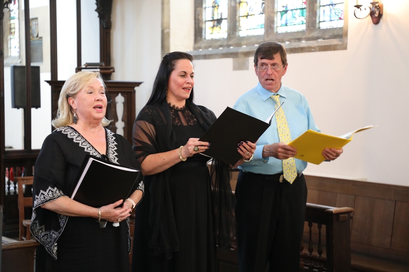 3 people singing in a chapel