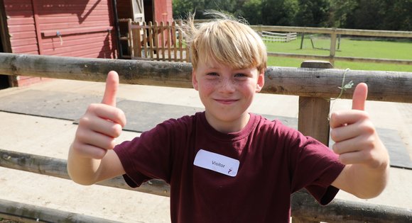 Boy giving two thumbs up.